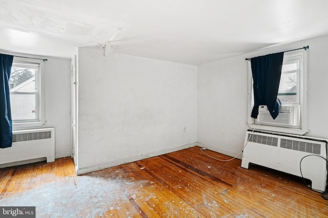 unfurnished room featuring hardwood / wood-style floors and radiator