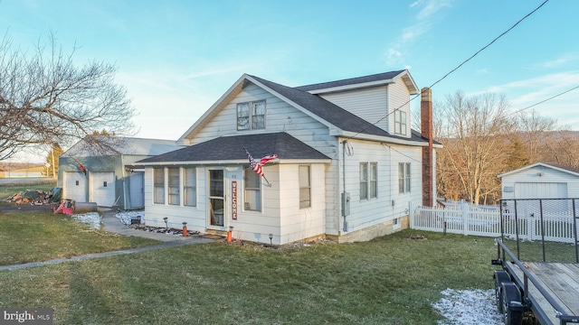 bungalow with a front yard, an outbuilding, and a garage