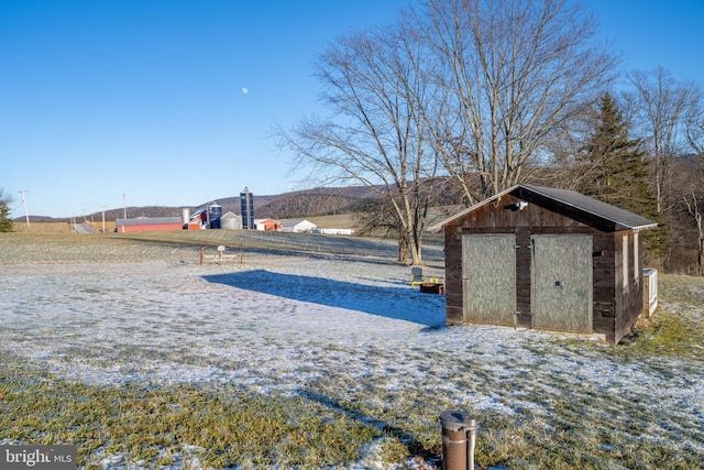 view of yard with a rural view and a storage shed