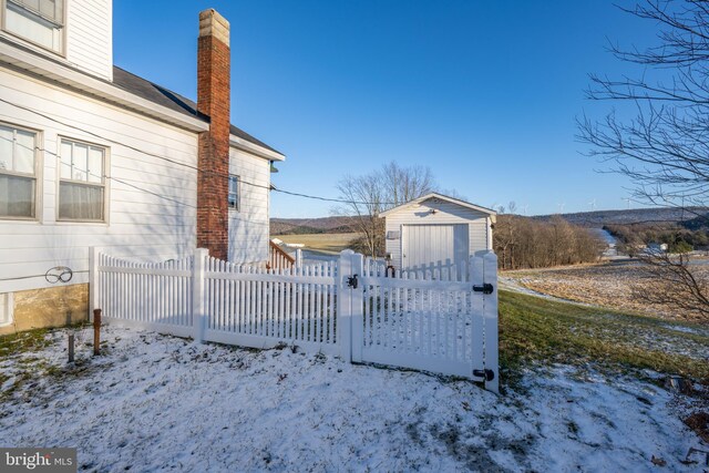 snow covered gate with a shed