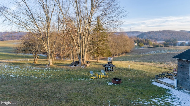 view of yard with a mountain view and a fire pit