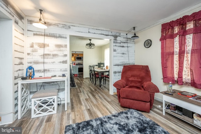 living area with hardwood / wood-style flooring and crown molding