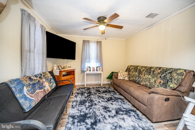 living room with light hardwood / wood-style flooring, ceiling fan, and crown molding