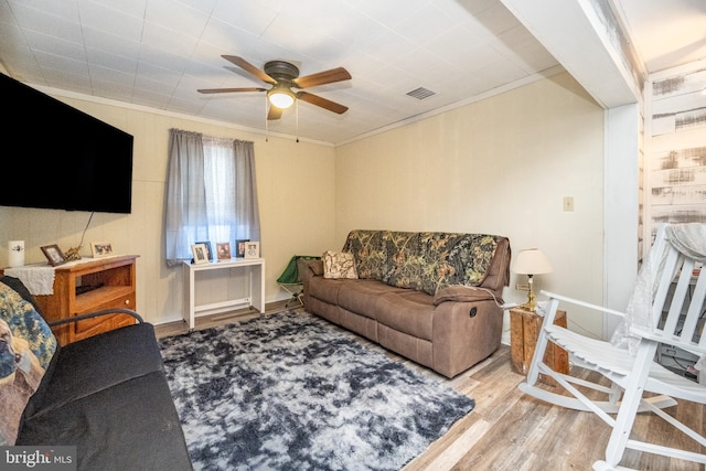 living room featuring ceiling fan, light hardwood / wood-style floors, and ornamental molding