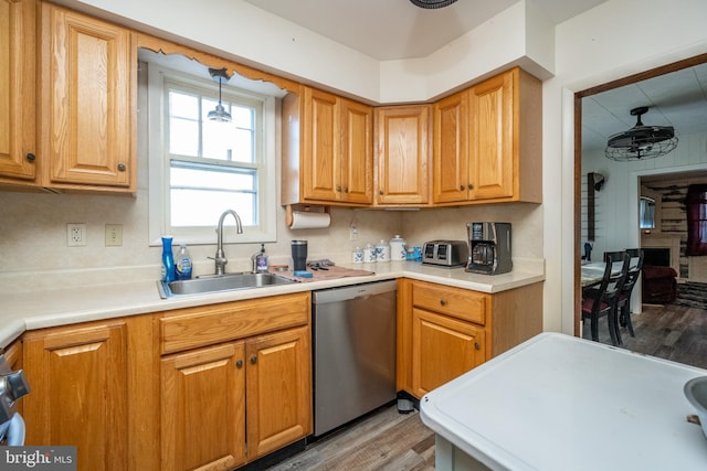 kitchen with ceiling fan, dishwasher, light wood-type flooring, and sink