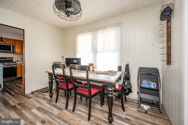 dining area featuring wooden walls and hardwood / wood-style flooring