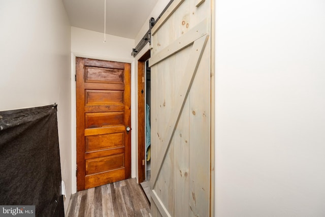 doorway to outside with wood-type flooring and a barn door