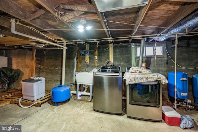 basement featuring independent washer and dryer and sink