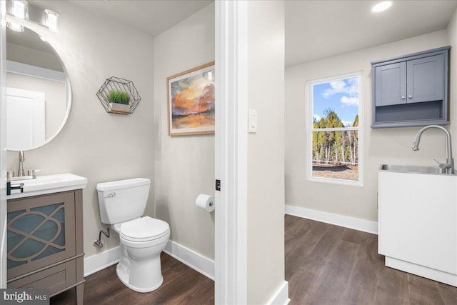 bathroom with wood-type flooring, vanity, and toilet