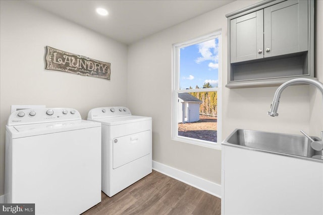 washroom featuring dark wood-type flooring, washer and clothes dryer, cabinets, and sink