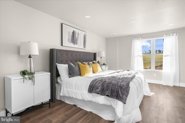 bedroom with radiator heating unit and dark wood-type flooring