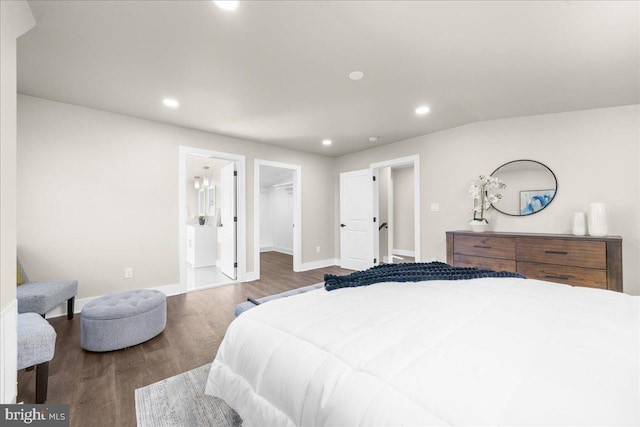 bedroom featuring a walk in closet, ensuite bathroom, vaulted ceiling, hardwood / wood-style floors, and a closet