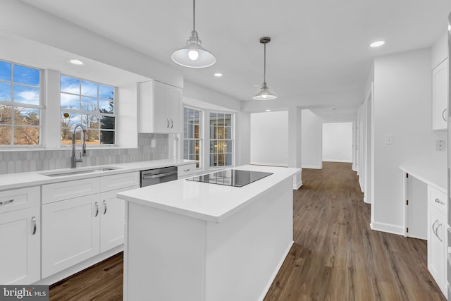 kitchen featuring black electric stovetop, sink, dishwasher, white cabinets, and a center island