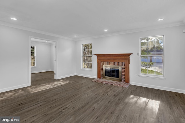 unfurnished living room featuring ornamental molding, a brick fireplace, and dark wood-type flooring