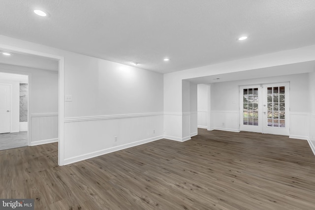 spare room with dark hardwood / wood-style flooring, a textured ceiling, and french doors