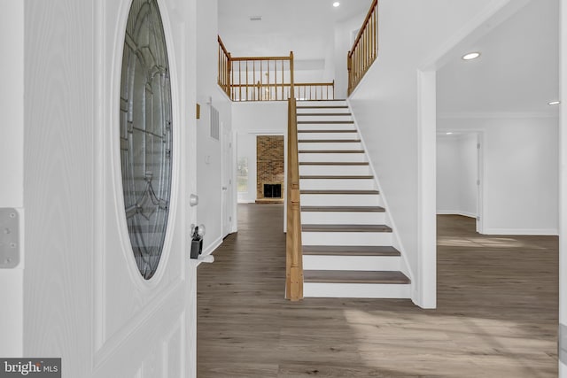 foyer with a fireplace, dark hardwood / wood-style flooring, and ornamental molding