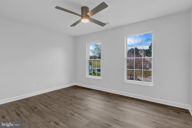 empty room with ceiling fan and dark wood-type flooring