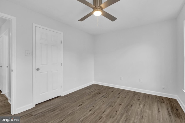 empty room featuring ceiling fan and dark wood-type flooring