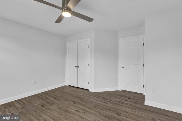 unfurnished bedroom featuring ceiling fan, dark hardwood / wood-style flooring, and a closet