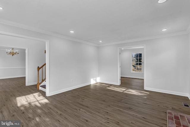 empty room with dark hardwood / wood-style flooring, a chandelier, and ornamental molding