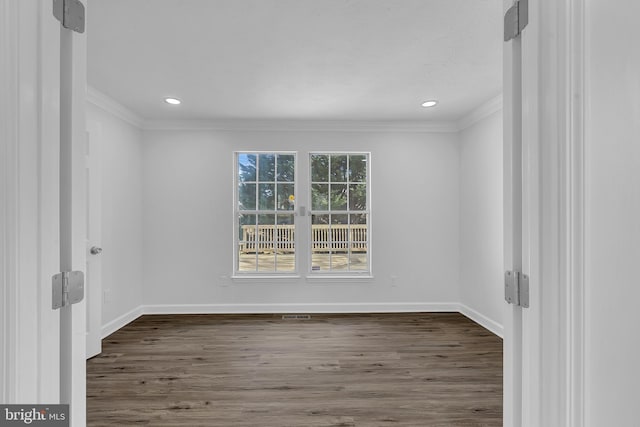 spare room featuring dark hardwood / wood-style floors and ornamental molding