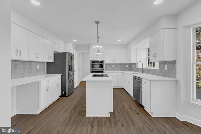 kitchen featuring white cabinets, a center island, a healthy amount of sunlight, and appliances with stainless steel finishes