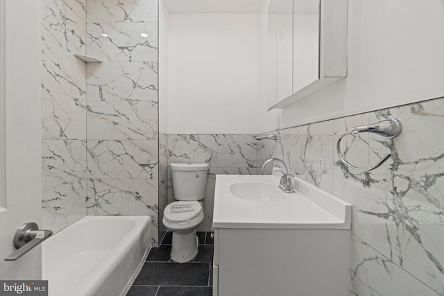 bathroom with tile patterned floors, vanity, toilet, and tile walls