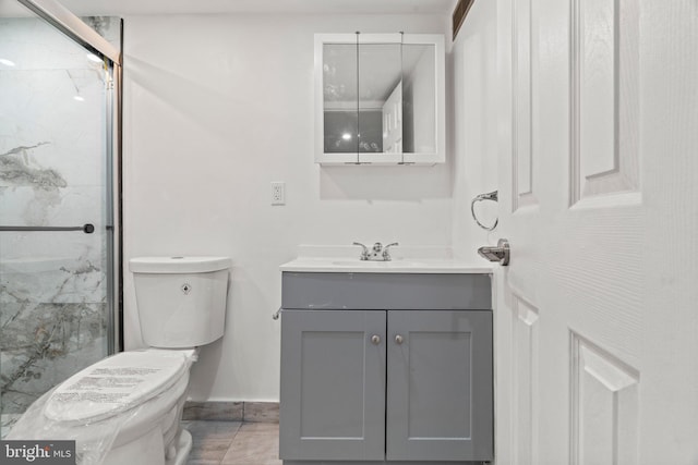 bathroom with vanity, toilet, and a shower with shower door