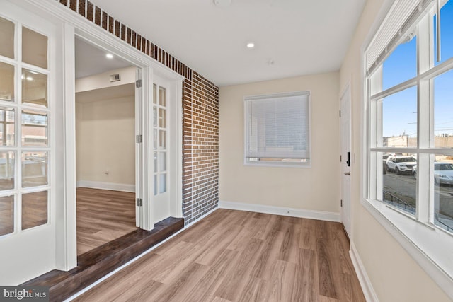 empty room with wood-type flooring and french doors