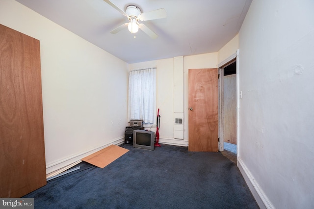 unfurnished bedroom featuring ceiling fan and dark carpet