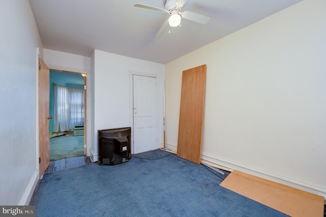 unfurnished living room featuring dark colored carpet and ceiling fan