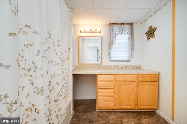 bathroom with a paneled ceiling and vanity