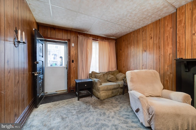 sitting room with carpet flooring and wood walls