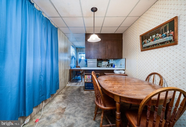 dining area featuring a drop ceiling and dark carpet