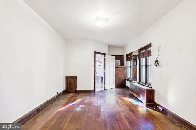 interior space featuring radiator heating unit and dark wood-type flooring