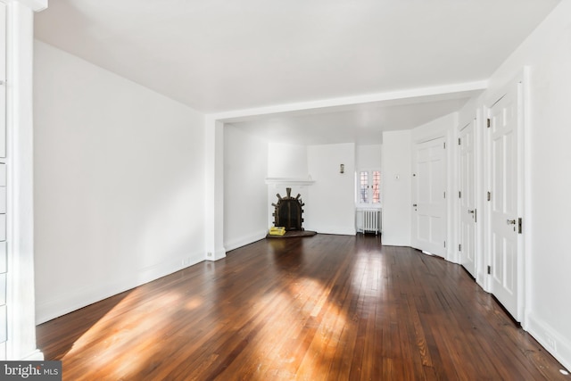 spare room featuring radiator heating unit and dark hardwood / wood-style flooring