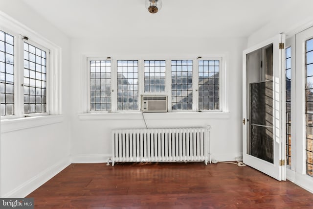 interior space featuring radiator, plenty of natural light, cooling unit, and dark hardwood / wood-style flooring