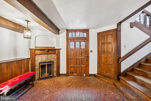 entrance foyer featuring a fireplace and wooden walls