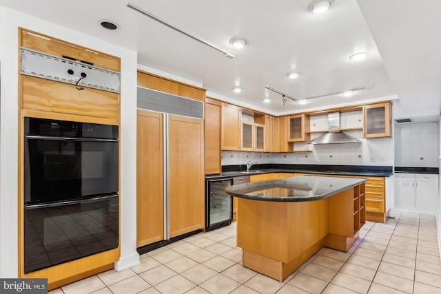 kitchen featuring wall chimney exhaust hood, a kitchen island, light tile patterned floors, and wine cooler