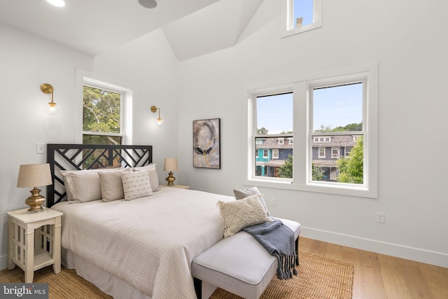 bedroom with hardwood / wood-style floors and lofted ceiling