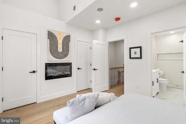 bedroom featuring light hardwood / wood-style floors and ensuite bath