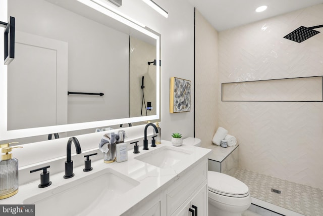 bathroom featuring tiled shower, vanity, and toilet