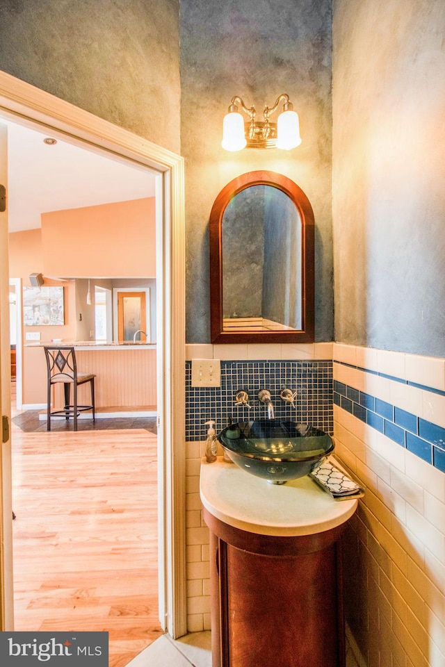 bathroom with vanity, wood-type flooring, and tile walls