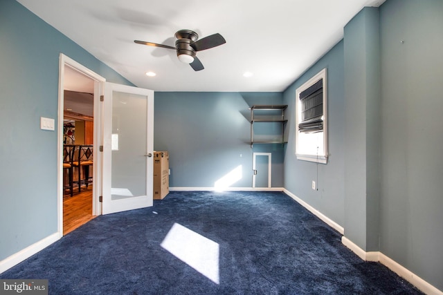 unfurnished living room with ceiling fan and dark carpet