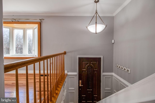 staircase with ornamental molding and hardwood / wood-style flooring