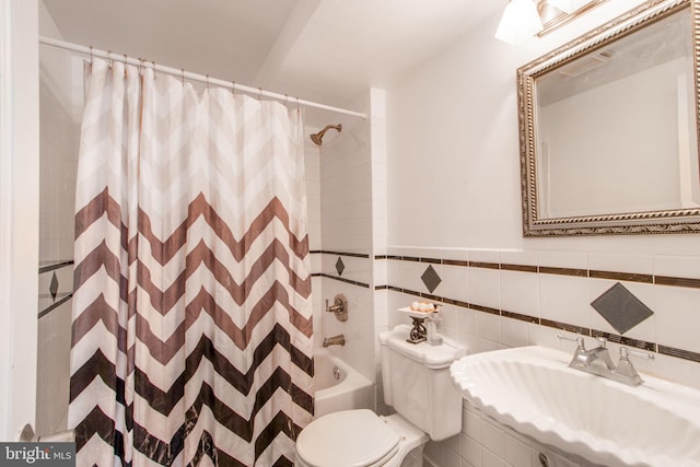 full bathroom with toilet, sink, shower / bathtub combination with curtain, and tile walls