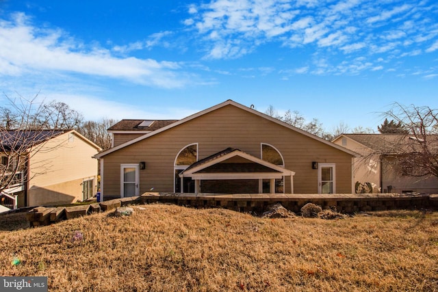 rear view of house featuring a yard