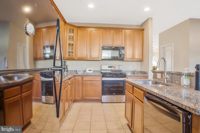 kitchen with light stone counters, sink, light tile patterned flooring, and appliances with stainless steel finishes