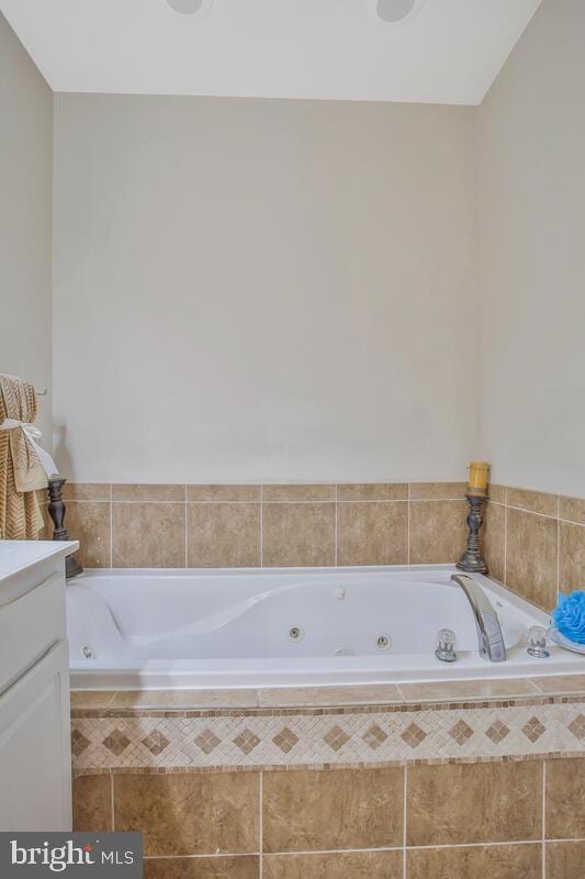 bathroom featuring vanity and a relaxing tiled tub