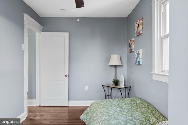 bedroom featuring hardwood / wood-style flooring, ceiling fan, and multiple windows